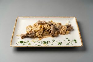 Pasta with beef fillet and mushrooms in white sauce